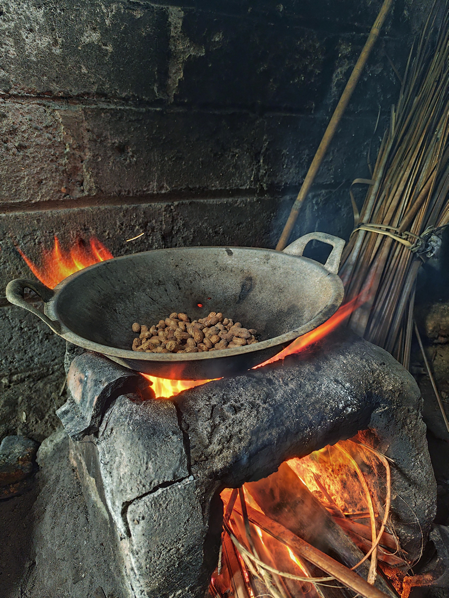 Holzbefeuerter Ofen, auf dem eine Pfanne erhitzt wird