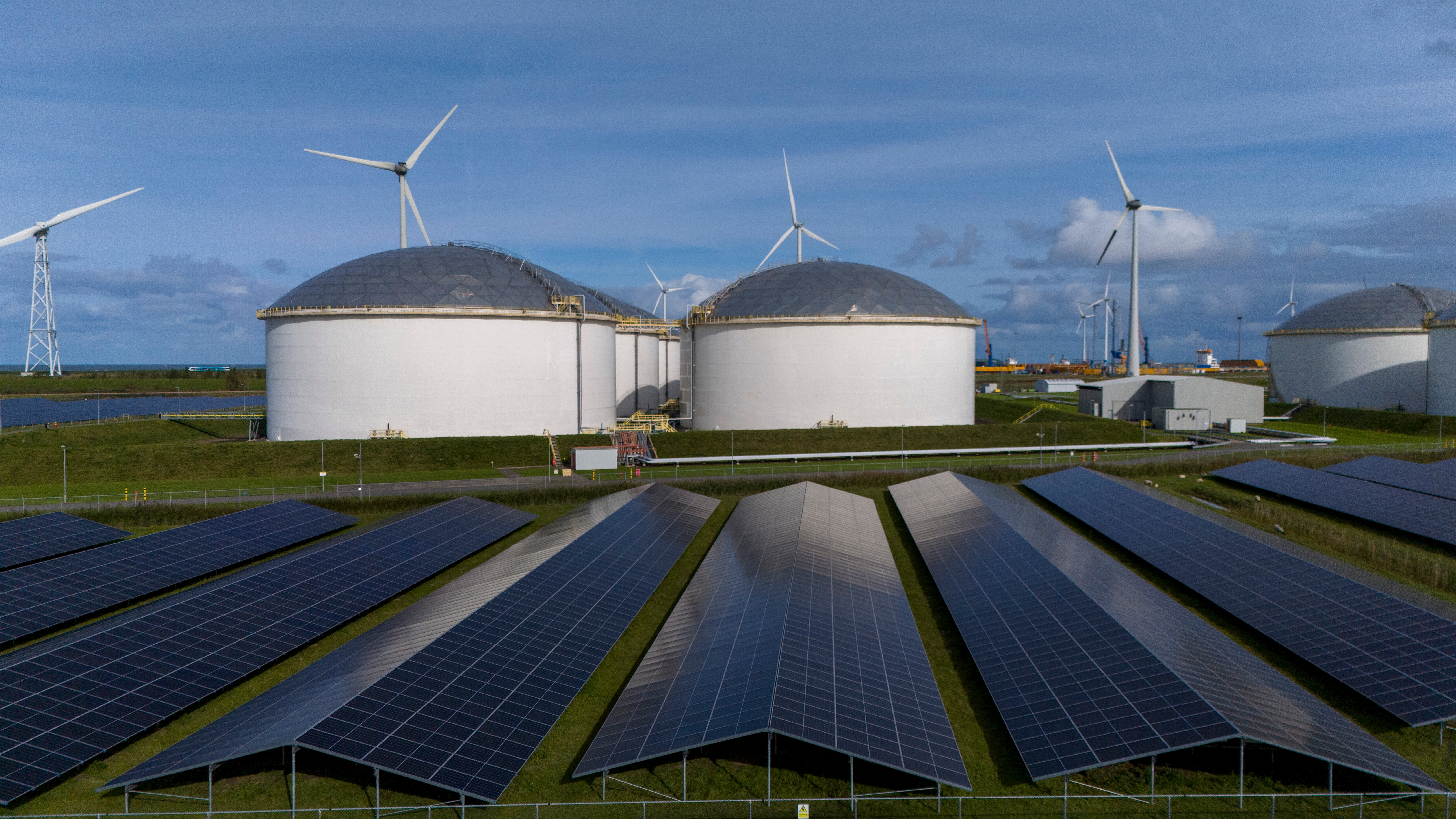 Foto PV-Anlagen, Biogasanlage und Windräder im Hintergrund